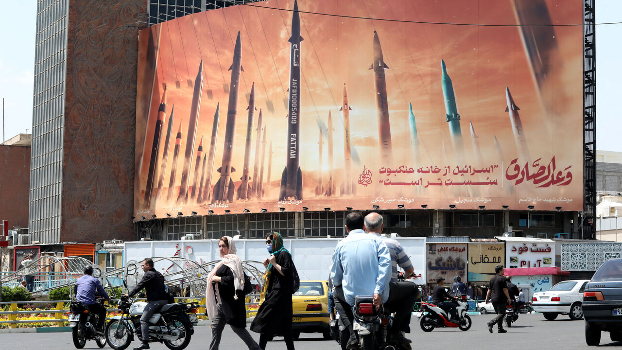 Motorists drive their vehicles past a billboard depicting Iranian missiles in Tehran on April 20, 2024, a day after Iran's state media reported explosions in the central province of Isfahan. (Photo by ATTA KENARE / AFP) (Photo by ATTA KENARE/AFP via Getty Images)
