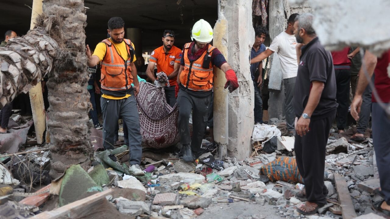 A corpse is removed after an Israeli strike on a school sheltering displaced people in Gaza City