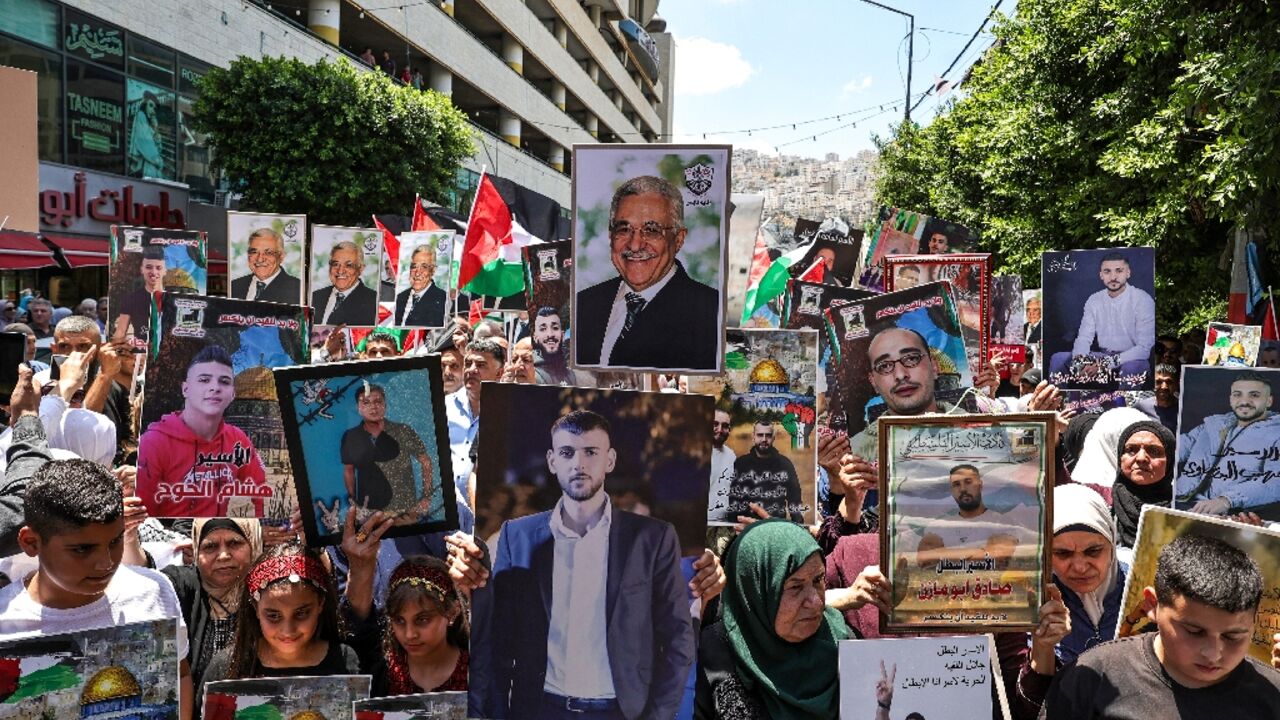 Palestinians hold up pictures of loved ones in Israeli custody at a rally in the West Bank city of Nablus called to protest recent reports of abuse and even torture