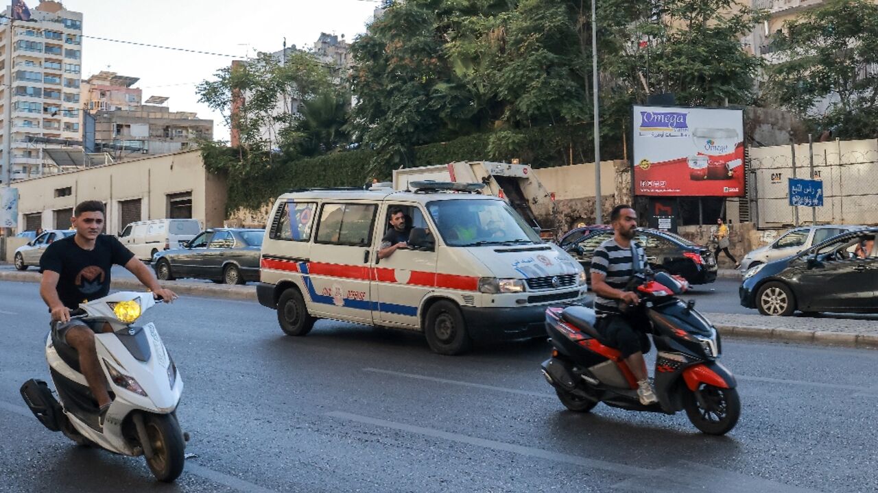 A Lebanese Red Cross ambulance rushes wounded people to hospital in Beirut after explosions hit Hezbollah strongholds around the country