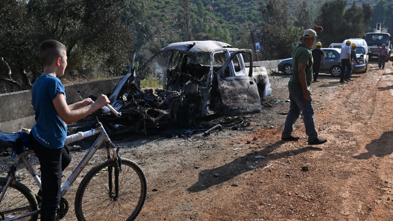 Syrians inspect the damage at the site of overnight Israeli strikes on the outskirts of Masyaf in Syria's central Hama province