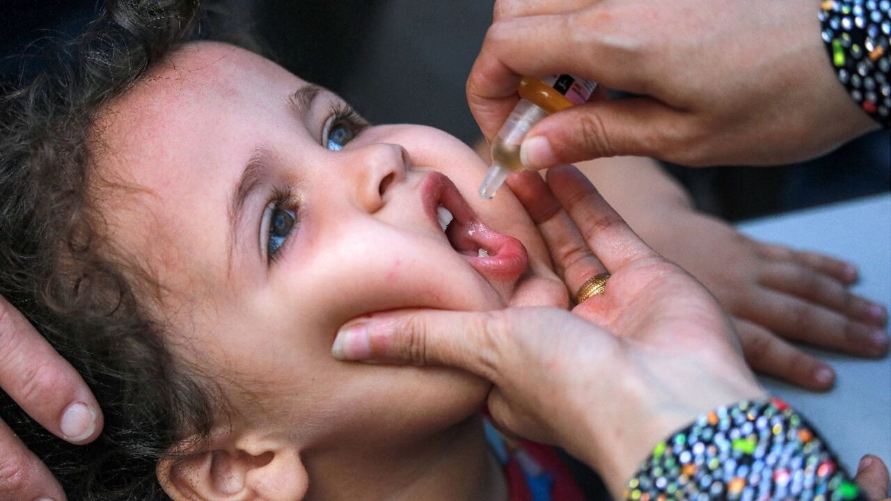 A child receives drops for the polio vaccine in Khan Yunis on September 5, 2024