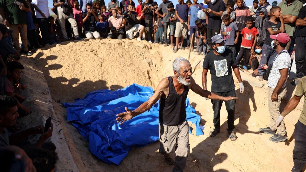 A crowd gathers for the burial in Khan Yunis of some of the 88 bodies the Palestinian health ministry says entered Gaza from Israel the day before