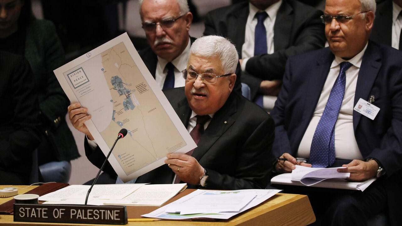 Palestinian President Mahmoud Abbas holds up a Vision for Peace map while speaking at the United Nations Security Council, New York, Feb. 11, 2020.