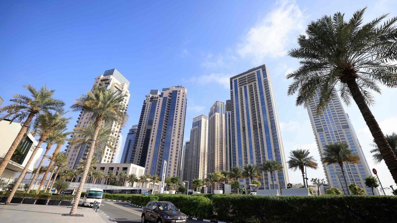 Cars drive along a street in front of high-rise buildings in Dubai, on February 18, 2023. - Home to towering skyscrapers and ultra-luxury villas, Dubai saw record real estate transactions in 2022, largely due to an influx of wealthy investors, especially from Russia. (Photo by Karim SAHIB / AFP) (Photo by KARIM SAHIB/AFP via Getty Images)