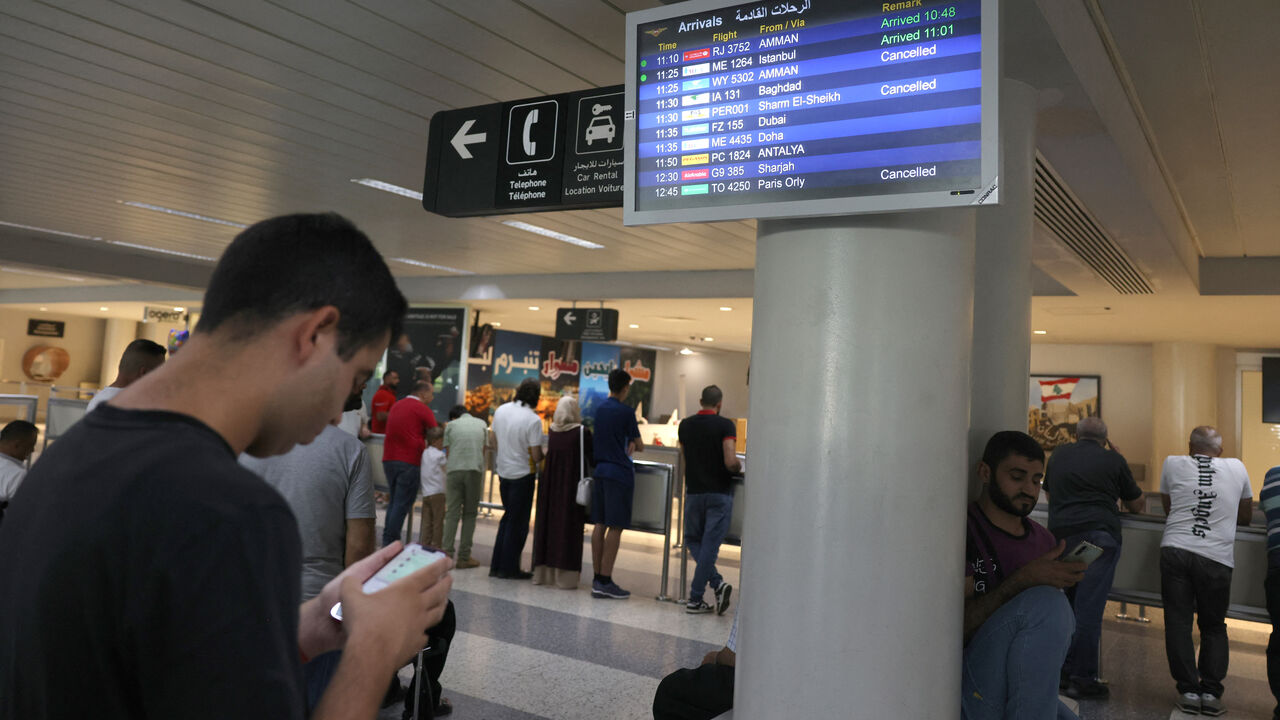 Passengers check their flight times at the Beirut International Airport in Beirut on August 25, 2024, amid escalations in the ongoing cross-border tensions between Hezbollah and Israel. The Beirut airport did not close but some airlines, including Royal Jordanian and Etihad Airways, cancelled flights. (Photo by ANWAR AMRO / AFP) (Photo by ANWAR AMRO/AFP via Getty Images)