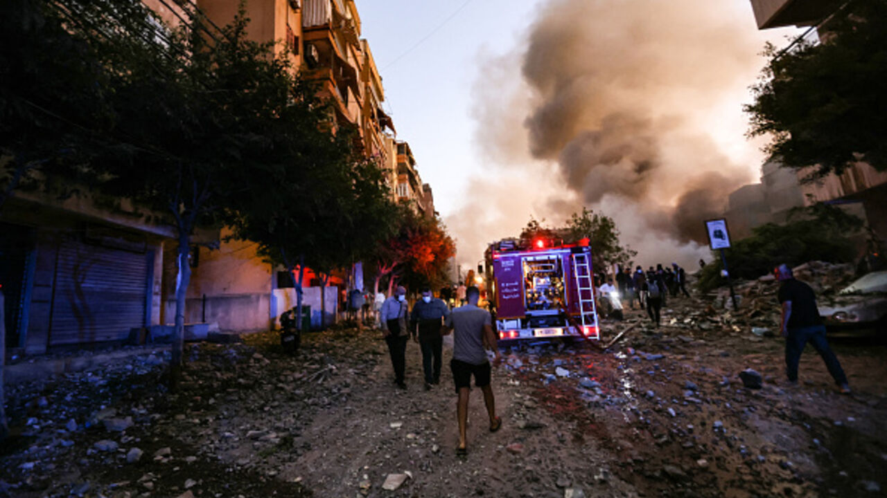 People and a fire truck rush to the scene of an Israeli air strike in the Haret Hreik neighbourhood of Beirut's southern suburbs on September 27, 2024. A source close to Hezbollah said the massive Israeli strikes on Beirut's southern suburbs flattened six buildings. (Photo by Ibrahim AMRO / AFP) (Photo by IBRAHIM AMRO/AFP via Getty Images)