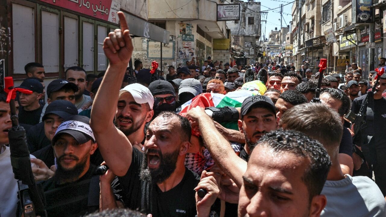 Pallbearers carry the body of Palestinian militant Wael Masha through the streets of Balata refugee camp in the occupied West Bank after he was killed in an Israeli air strike on August 15, less than a year after he was released in a prisoner swap