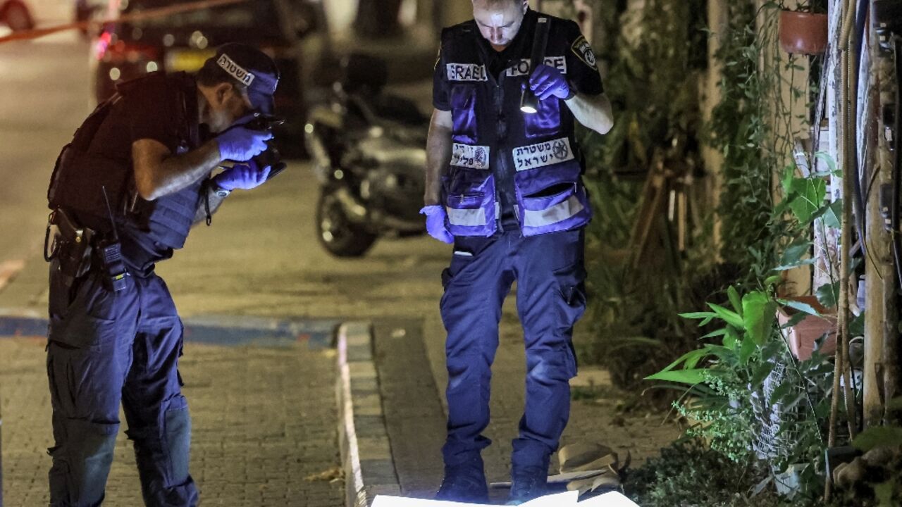 Police forensics experts examine the scene of the deadly knife and gun attack in the Jaffa district of Israel's commercial hub Tel Aviv