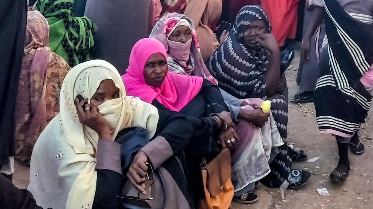 People from Khartoum and al-Jazira states, displaced by the war between Sudan's army and paramilitaries, wait to receive aid from a charity organisation in Gedaref, eastern Sudan, on December 30, 2023