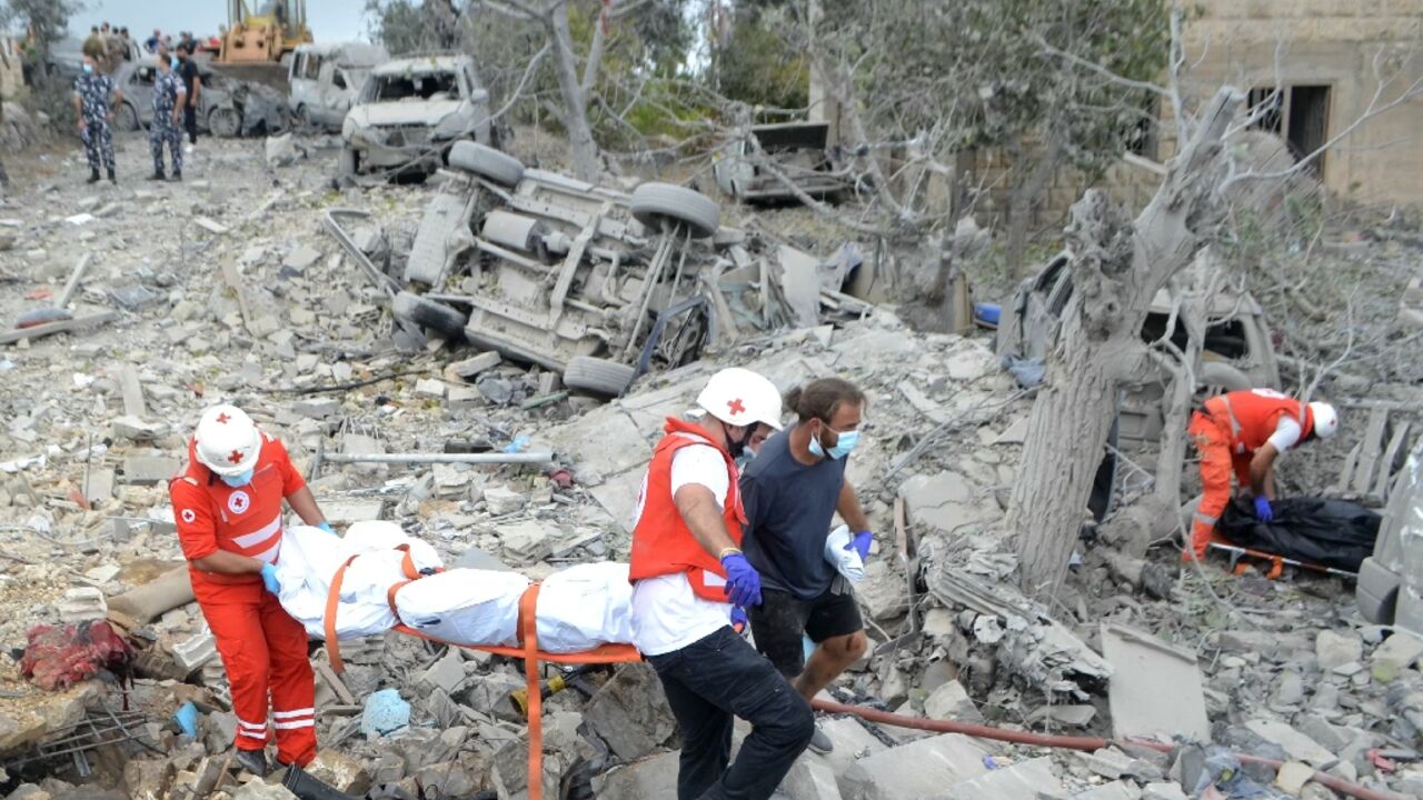 Lebanese Red Cross paramedics transport a body unearthed from the rubble at the site of an Israeli air strike that targeted Aito village in a Christian-majority area far from Hezbollah strongholds