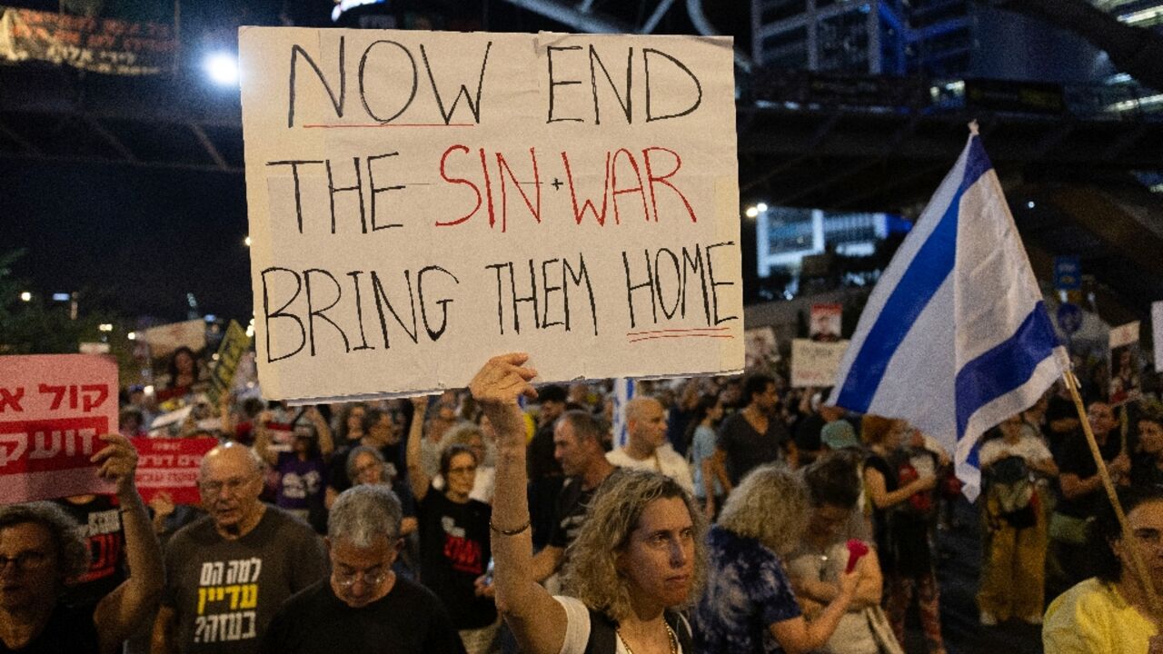 Supporters and relatives of Israelis held hostage by Palestinian militants in Gaza protest outside the Ministry of Defence in Tel Aviv for their release