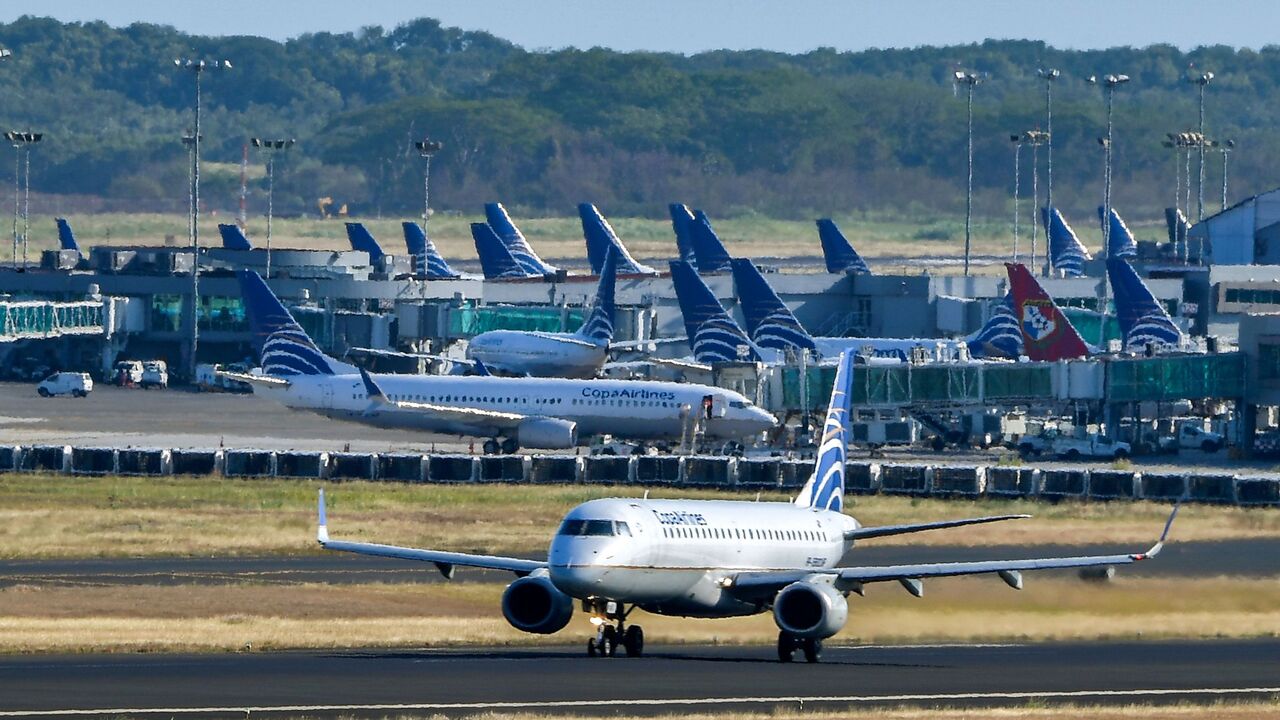 A Copa airlines plane taxis on a runway as others sit on the tarmac at Tocumen International Airport, on March 22, 2020.