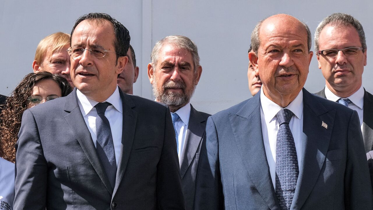 Cyprus' President Nikos Christodoulides (L) and Turkish Cypriot leader Ersin Tatar (R) speak to reporters outside the anthropological laboratory of the Committee on Missing Persons in Cyprus (CMP) in the United Nations buffer zone splitting the divided capital Nicosia on July 28, 2023. 