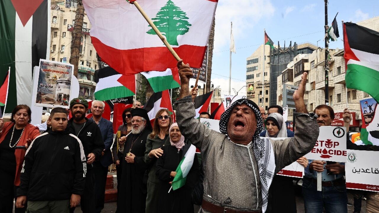 Protesters carry Lebanese flags during a rally to mark the anniversary of Palestinian militant group Hamas's October 7, 2023 attack on Israel, in Ramallah in the occupied West Bank