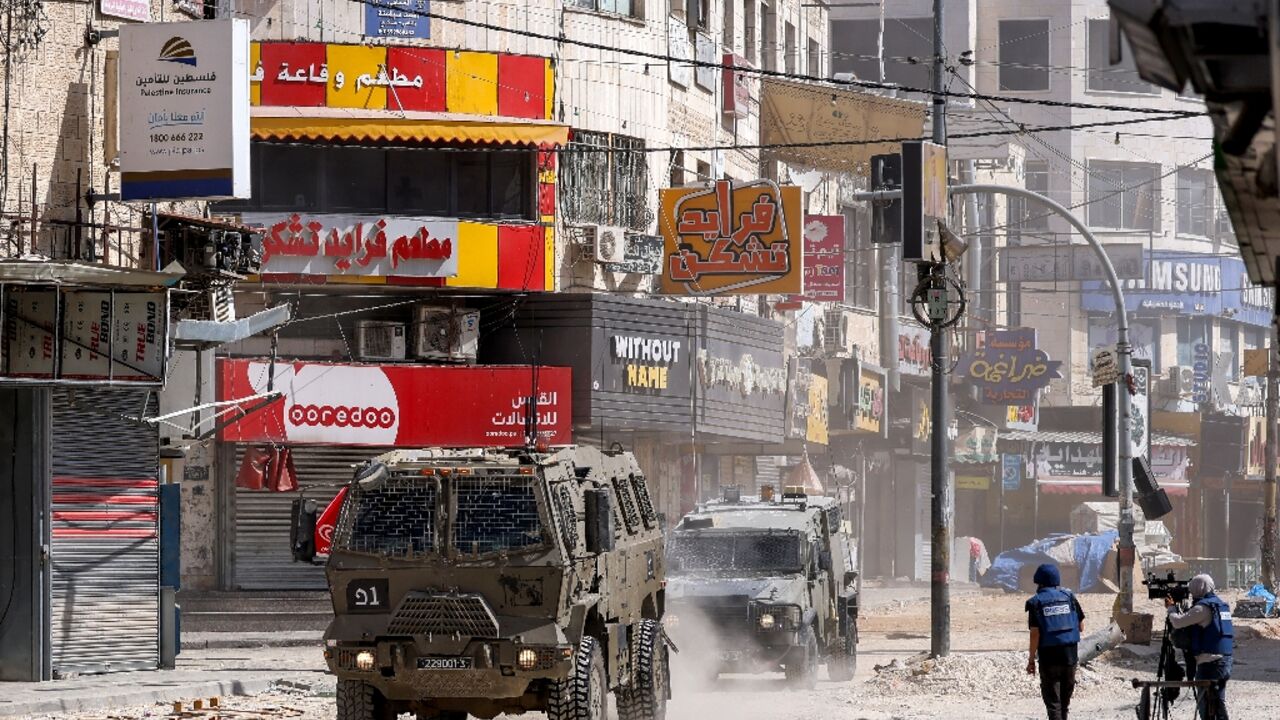 Journalists cover the deployment of Israeli armoured vehicles during a raid in the Jenin camp for Palestinian refugees in the occupied West Bank 