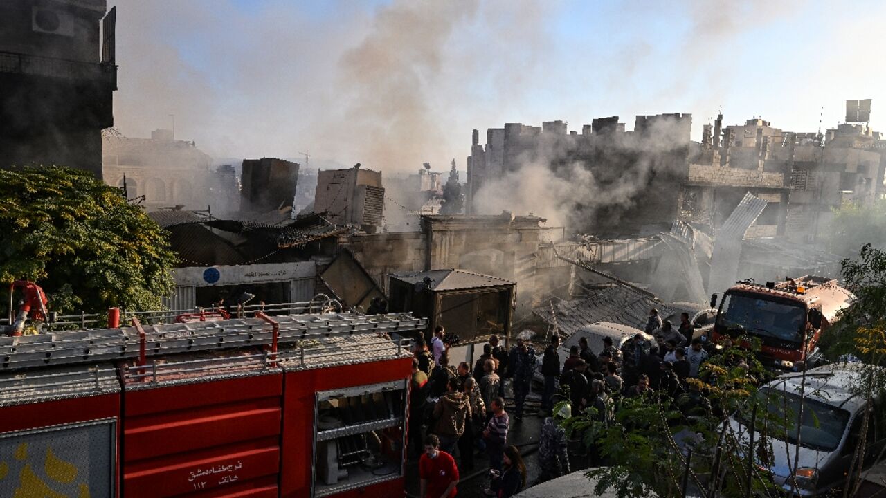 People check the damage following what a war monitor called an Israeli strike, that left Iran-backed fighters among the dead, in the Mazzeh district of Damascus 