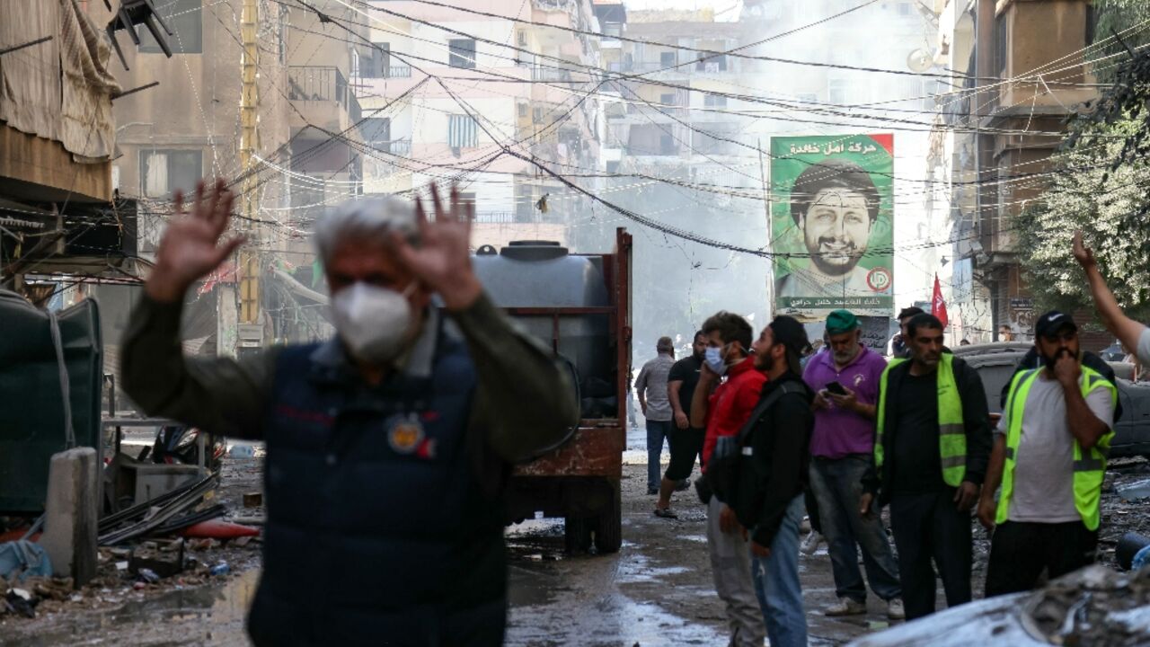 People and rescuers at the site of an Israeli air strike in Beirut's southern suburbs