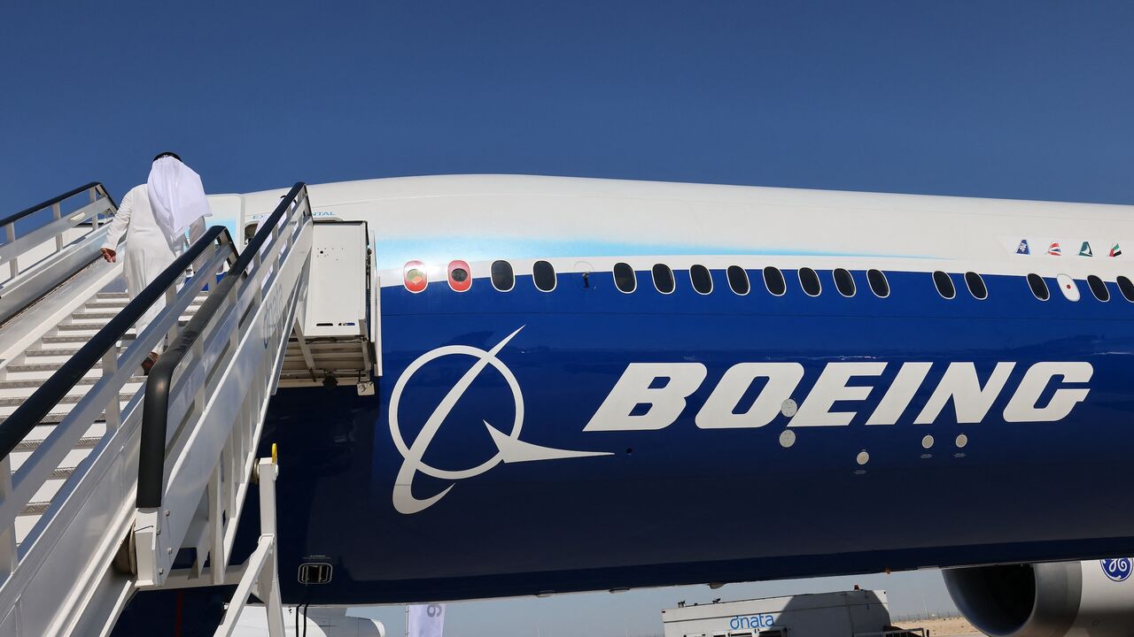 A man climbs the ramp to enter the Boeing 777X demonstration aircraft at the 2021 Dubai Airshow in the Gulf emirate, on Nov. 14, 2021.