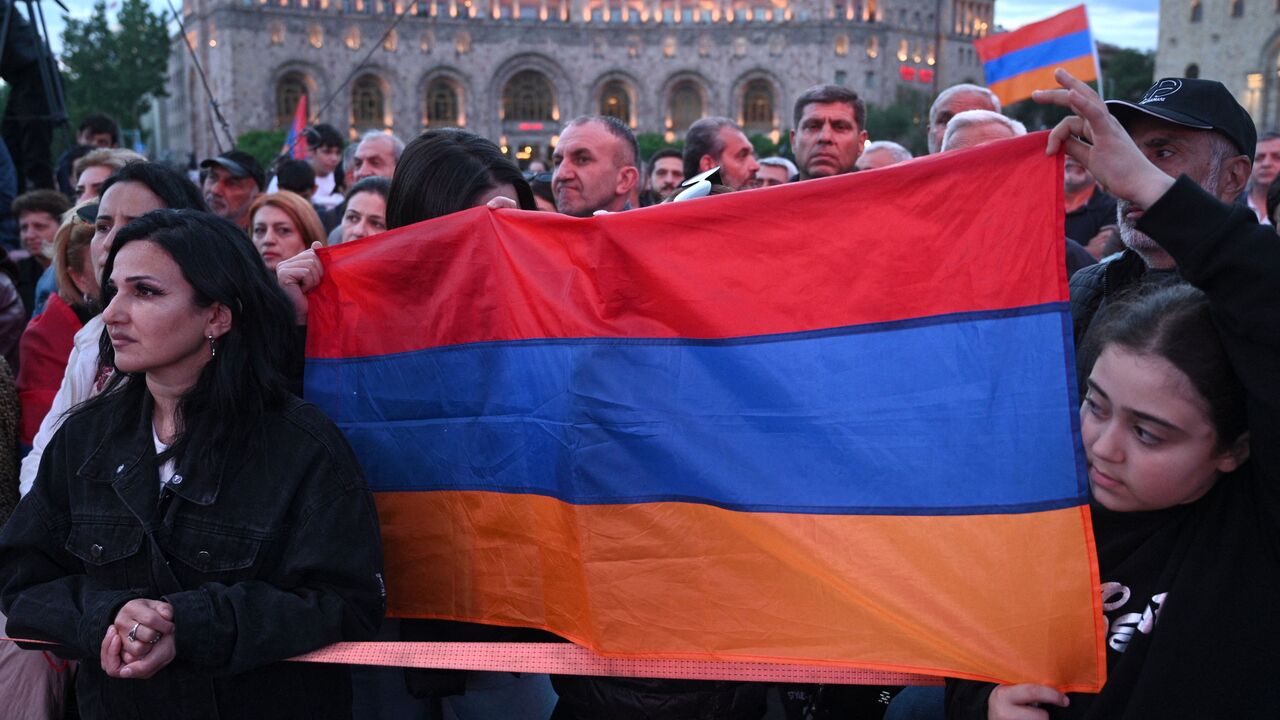 Armenian protesters hold a flag of Armenia as they gather to rally against land transfer to Azerbaijan, on Yerevan's Republic Square on May 10, 2024. Armenia has agreed to hand over territory it has controlled since the 1990s and started border delimitation efforts in a bid to secure an elusive peace deal with Baku and avoid another bloody conflict. (Photo by KAREN MINASYAN / AFP) (Photo by KAREN MINASYAN/AFP via Getty Images)