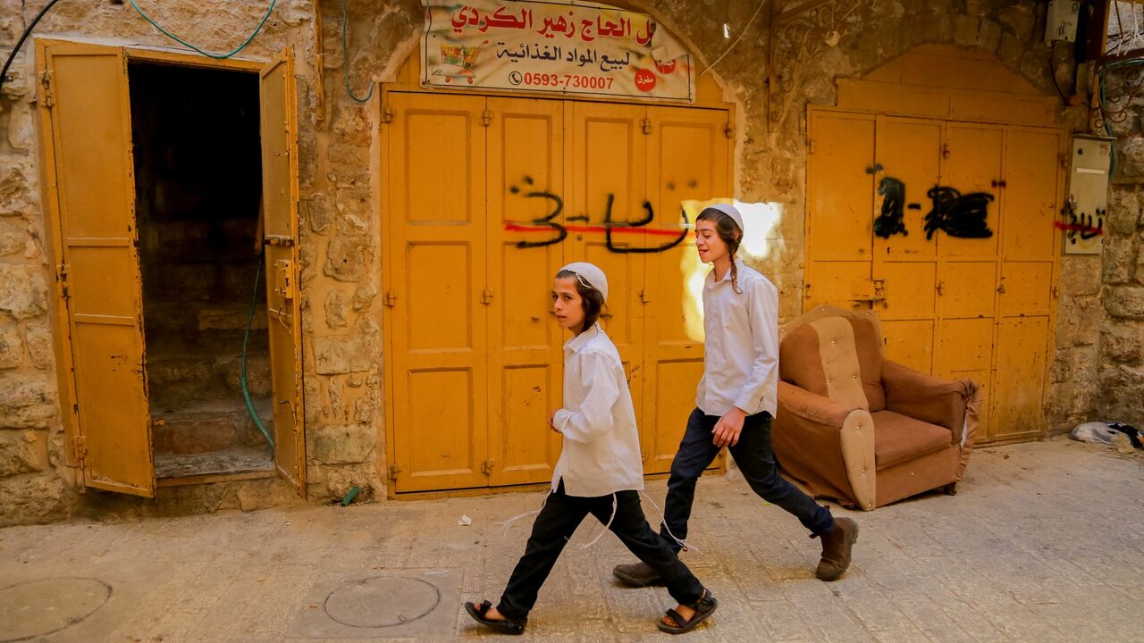 Israeli settlers walk through a street in Hebron's old city. Security is reinforced for the Jewish holiday of Sukkot, West Bank, on Oct. 22, 2024.