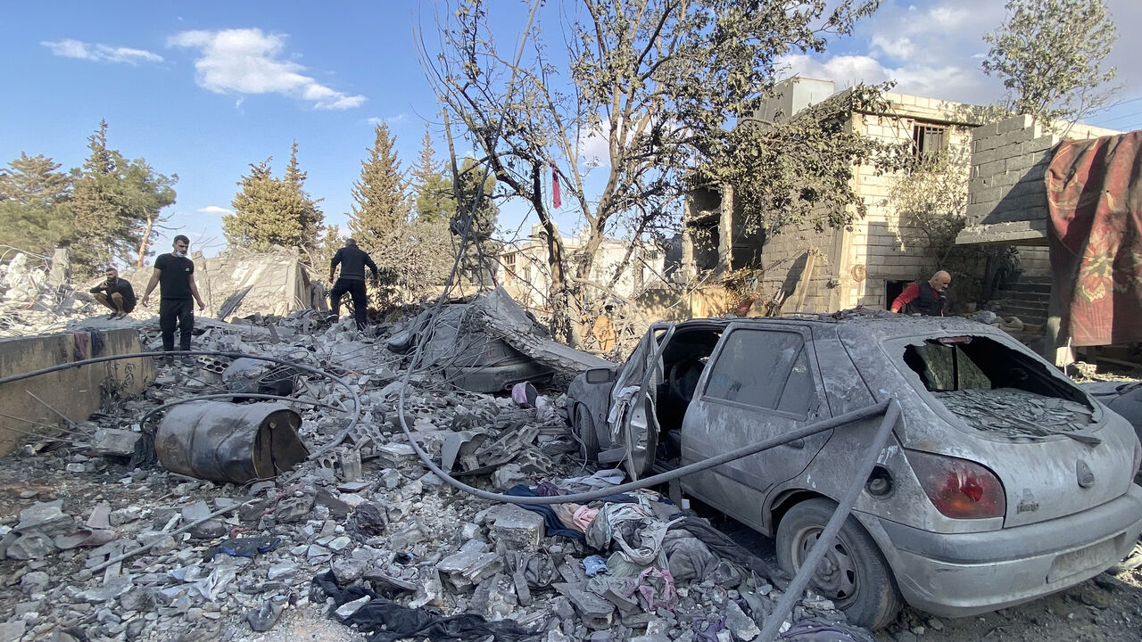 People check the destruction at the site of an Israeli airstrike that targeted the eastern village of Bazzaliyeh in the Hermel district of Lebanon's Bekaa Valley, near the border with Syria, Nov. 1, 2024.