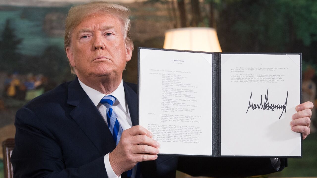 US President Donald Trump signs a document reinstating sanctions against Iran after announcing the US withdrawal from the Iran nuclear deal, in the Diplomatic Reception Room at the White House in Washington, DC, on May 8, 2018. 