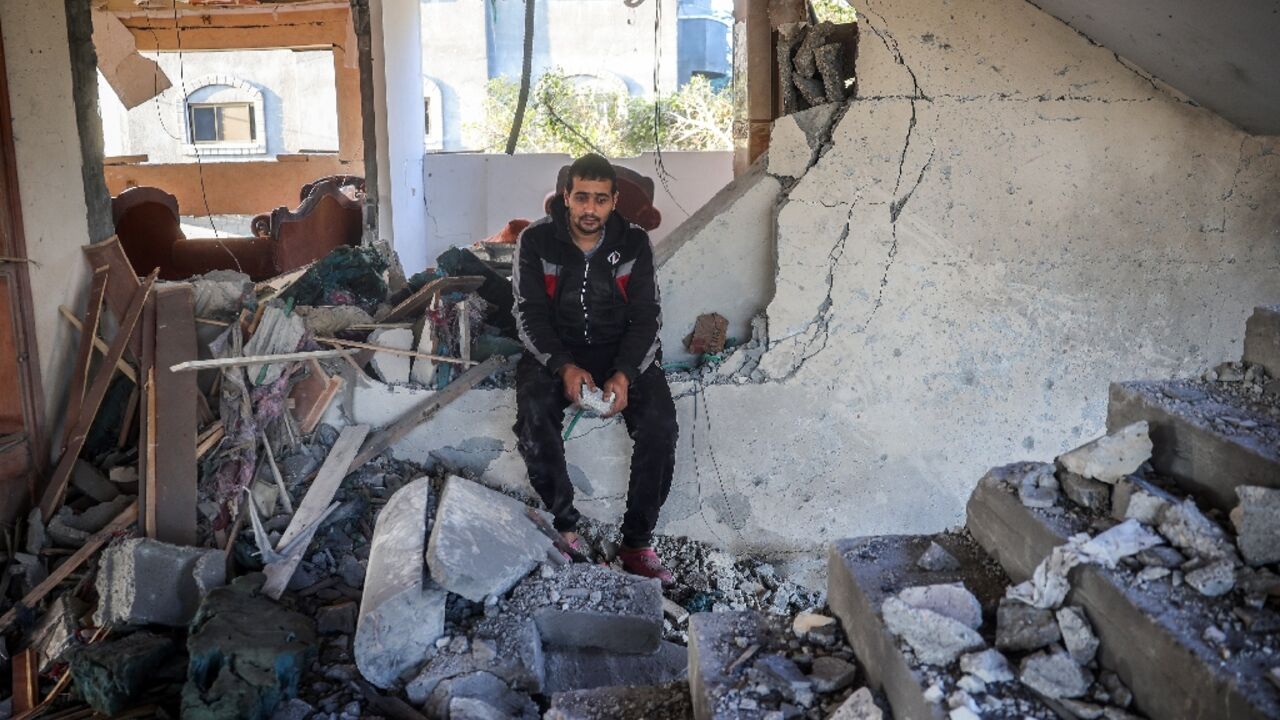 A man sits amid the rubble of  a building following an Israeli strike on the central Gaza city of Deir el-Balah