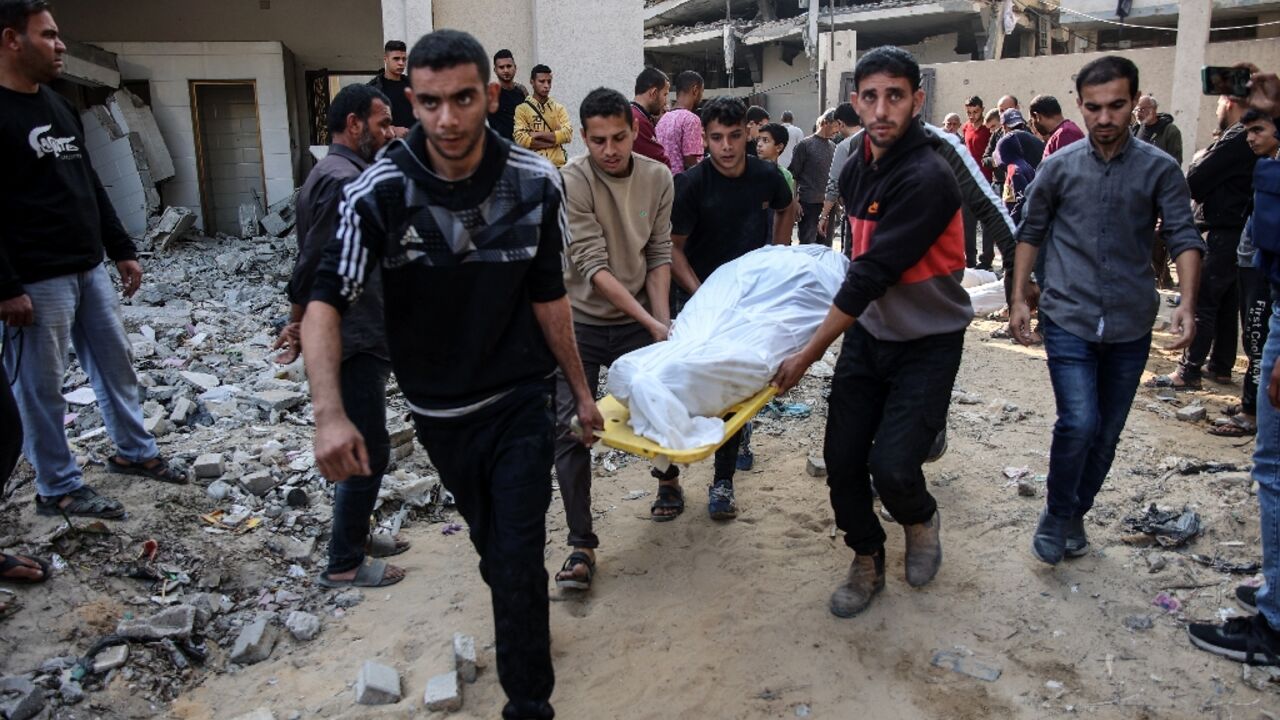 A white-shrouded body is removed from the site of the attack for burial in a Jabalia cemetery