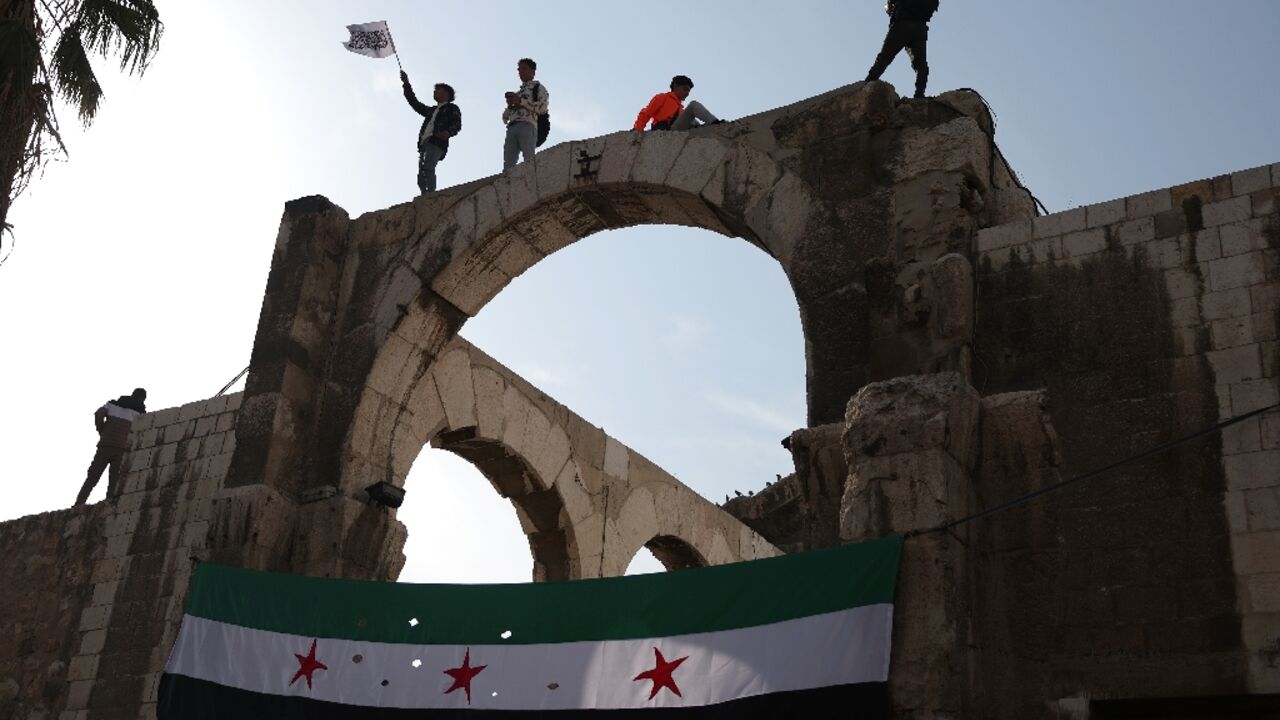 Syrians wave the independence-era flag after midday prayers at the Umayyad Mosque in Damascus on Friday