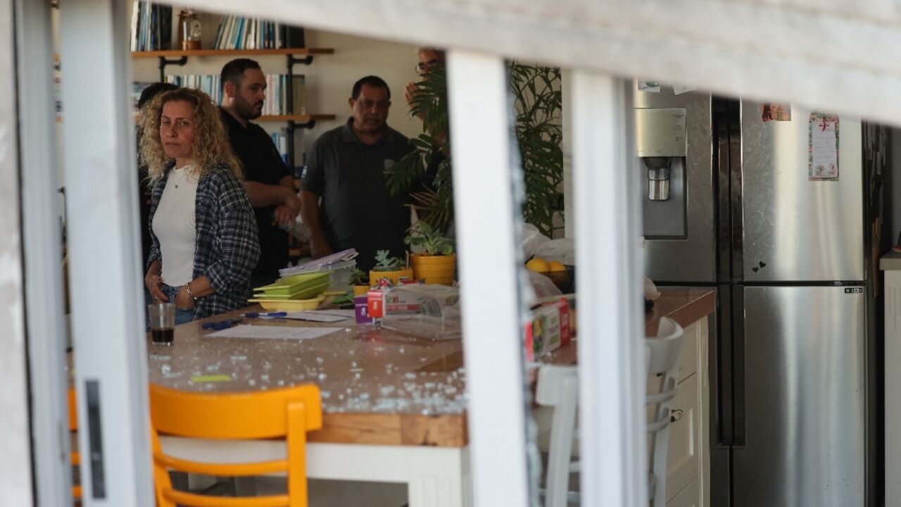 Israelis check the damage to their top-floor apartment in a residential building in central Israel hit by a Huthi drone from Yemen