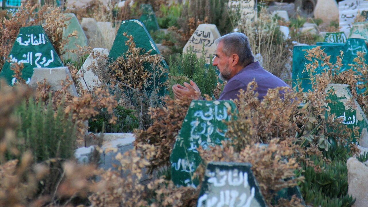 A Syrian man prays on July 12, 2017, at a cemetary in Khan Sheikhun