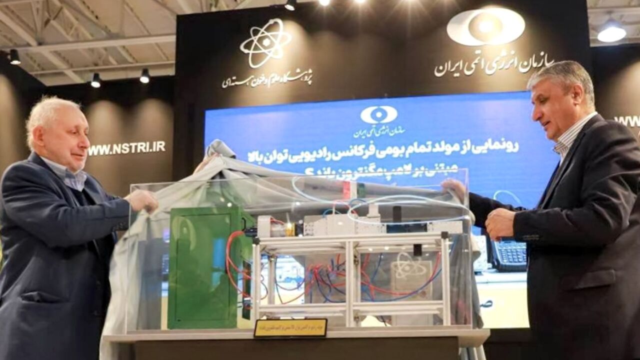 This handout picture provided by the Atomic Energy Organization of Iran shows the organization chief Mohammad Eslami (R) during a ceremony to unveil a domestically-made high power radio frequency generator