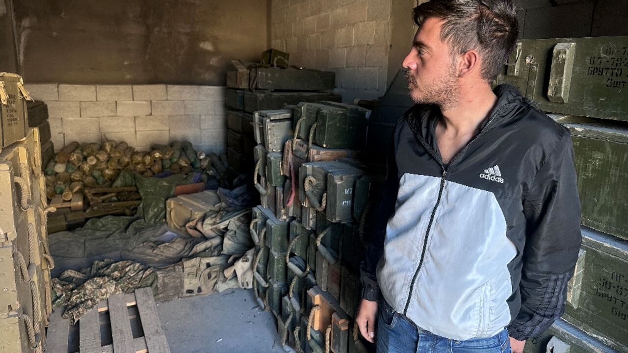 A Syrian man inspects an apparent weapons depot in the Sayyida Zeinab suburb of Damascus