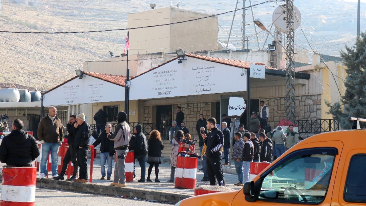 People wait at the entrance to the Masnaa eastern Lebanese border crossing after Syria imposed new restrictions on the entry of Lebanese citizens, according to two security officials