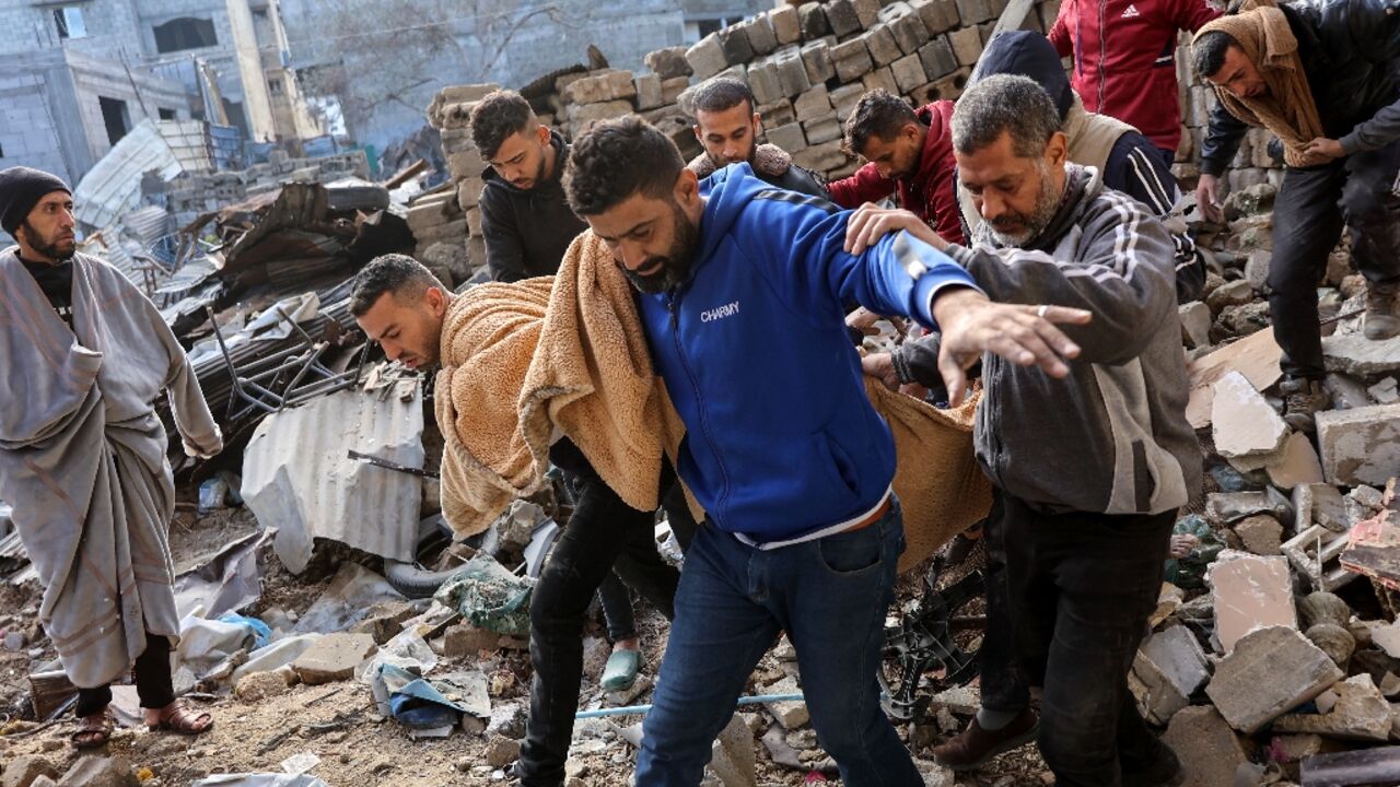 Palestinians carry a body after, according to Civil Defence rescuers, an Israeli strike on the al-Ghoula family home in the Gaza City area