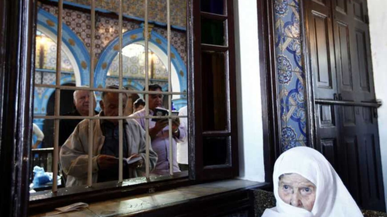 A woman listens as men read the Torah on the first day of a pilgrimage at the Ghriba synagogue in Djerba May 9, 2012. The Ghriba synagogue in Djerba, home to most of Tunisia's Jews, is built on the site of a Jewish temple that is believed to date back almost 1,900 years and attracts pilgrims each year. REUTERS/Anis Mili (TUNISIA - Tags: RELIGION TRAVEL POLITICS) - RTR31U3J