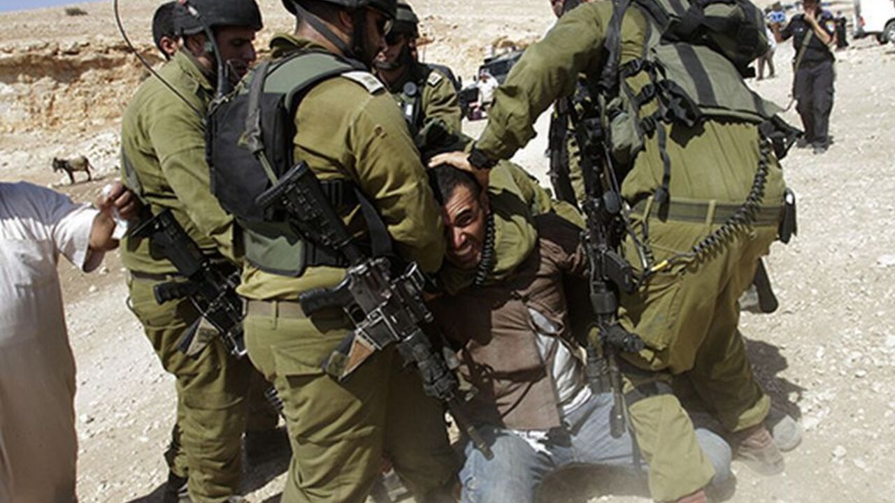 Israeli soldiers detain a Palestinian during scuffles following an attempt by European diplomats to deliver goods to locals in the West Bank herding community of Khirbet al-Makhul, in the Jordan Valley September 20, 2013. Israeli soldiers manhandled European diplomats on Friday and seized a truck full of tents and emergency aid they had been trying to deliver to Palestinians whose homes were demolished earlier this week. REUTERS/Abed Omar Qusini (WEST BANK - Tags: POLITICS CIVIL UNREST MILITARY TPX IMAGES O