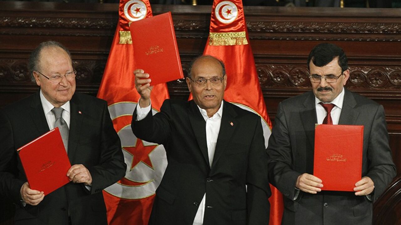 (L to R) Tunisia's National Assembly President Mustapha Ben Jaafar, President Moncef Marzouki and outgoing Prime Minister Ali Larayedh pose after signing the country's new constitution in Tunis January 27, 2014. Marzouki and the head of the National Assembly signed Tunisia's new constitution on Monday, enshrining one of its last steps toward full democracy after a 2011 uprising that inspired the Arab Spring. REUTERS/Anis Mili (TUNISIA - Tags: POLITICS) - RTX17WYC