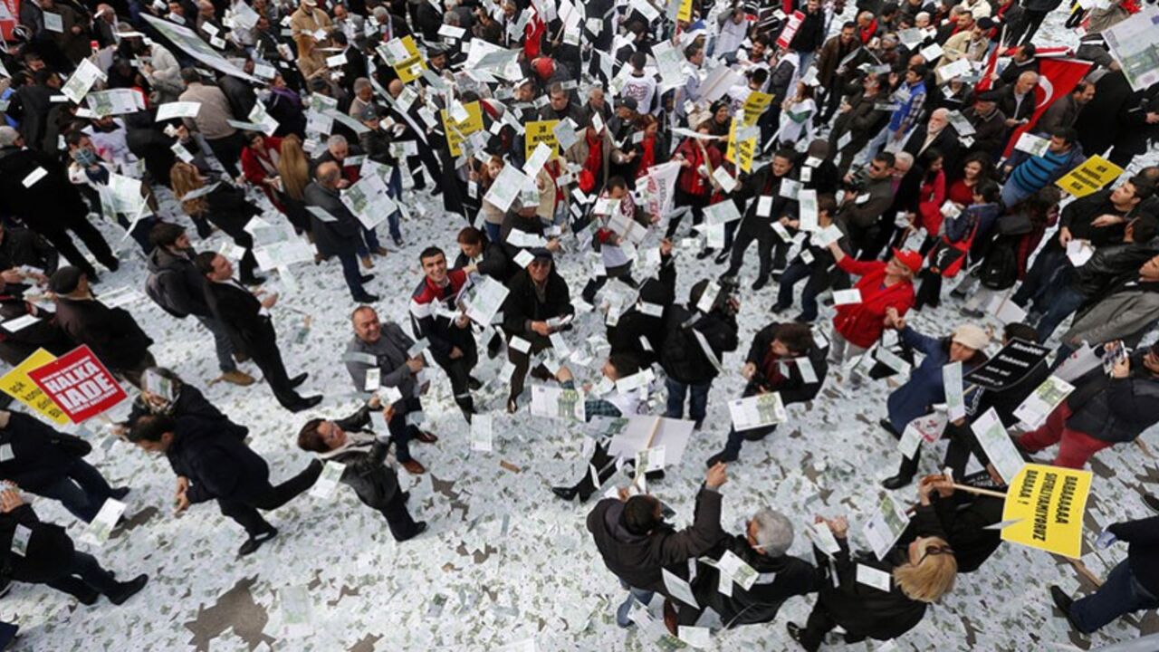 People play around with fake Euro notes during a demonstration against Turkey's Prime Minister Tayyip Erdogan in Ankara March 1, 2014. Supporters from Turkey's main opposition Republican People's Party (CHP) spread 30 million Euros in fake notes on a main street in central Ankara, according to opposition MP Levent Gok, to protest a phone conversation suggesting Erdogan warned his son Bilal to hide large sums of money before police raids during a graft inquiry that reached into the government. Erdogan accuse