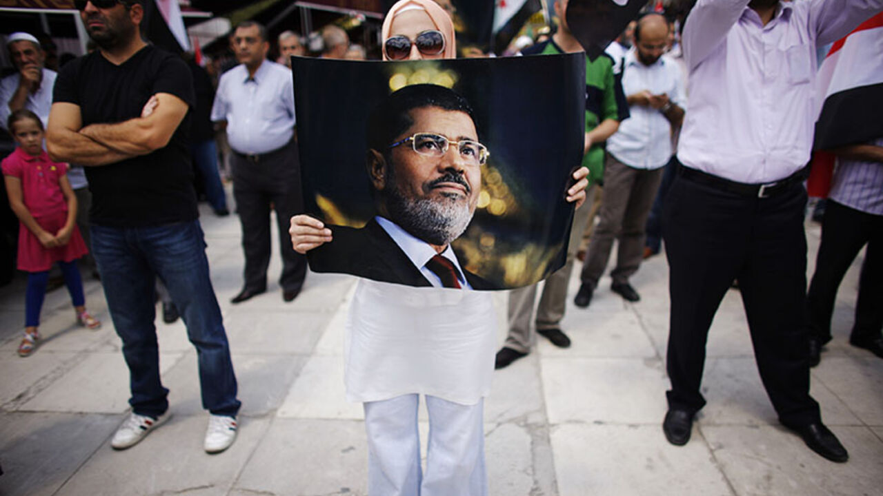 A woman holds a poster of deposed Egyptian President Mohamed Mursi during a pro-Islamist demonstration at the courtyard of Fatih mosque in Istanbul July 27, 2013. REUTERS/Murad Sezer (TURKEY - Tags: POLITICS CIVIL UNREST TPX IMAGES OF THE DAY) - RTX1213F