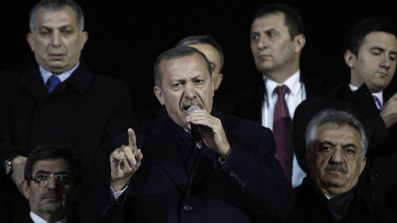 Turkey's Prime Minister Tayyip Erdogan (C) addresses his supporters upon his arrival to Ataturk Airport in Istanbul December 27, 2013. A Turkish court blocked a government attempt to force police to disclose investigations to their superiors, officials said on Friday, in a setback for Erdogan's attempts to manage fallout from a high-level corruption scandal. REUTERS/Osman Orsal (TURKEY - Tags: POLITICS CRIME LAW CIVIL UNREST) - RTX16V6A