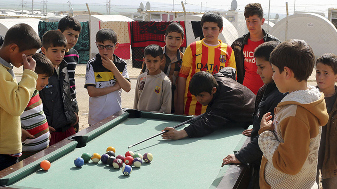 Yazidi refugee children play a game of pool at a refugee camp on the outskirts of Duhok, February 28, 2015. Picture taken February 28, 2015. REUTERS/Asmaa Waguih (IRAQ - Tags: CIVIL UNREST CONFLICT SOCIETY IMMIGRATION) - RTR4RLLV
