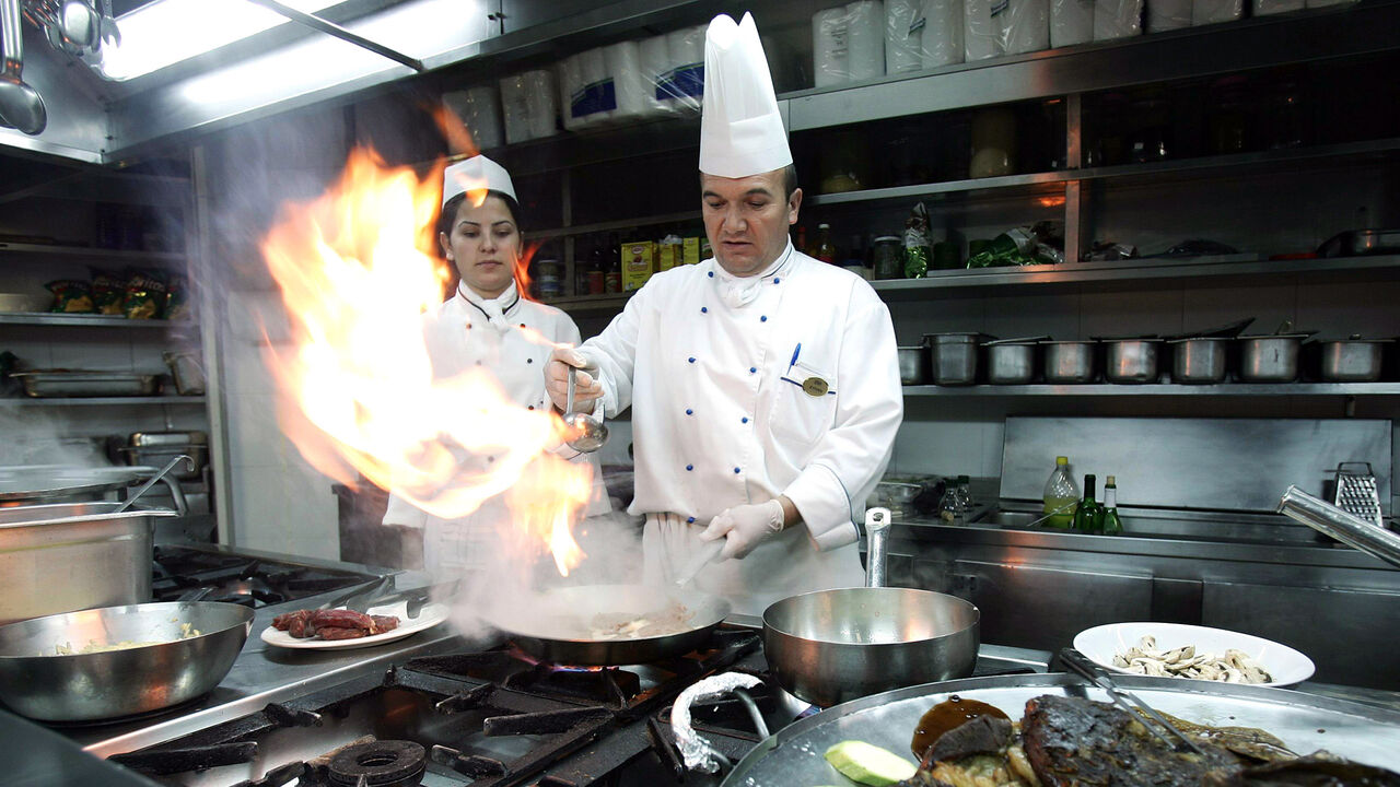A Turkish cook prepares a beef steak on fire at a restaurant in a five-star hotel in the Mediterranean Turkish city of Antalya, January 17, 2006. Turkey's top holiday destination Antalya is concerned by the westward spread of the bird flu disease towards the city blessed by a long Mediterranean coast. Photo taken January 17, 2006. REUTERS/Umit Bektas - RP3DSFDNCIAC