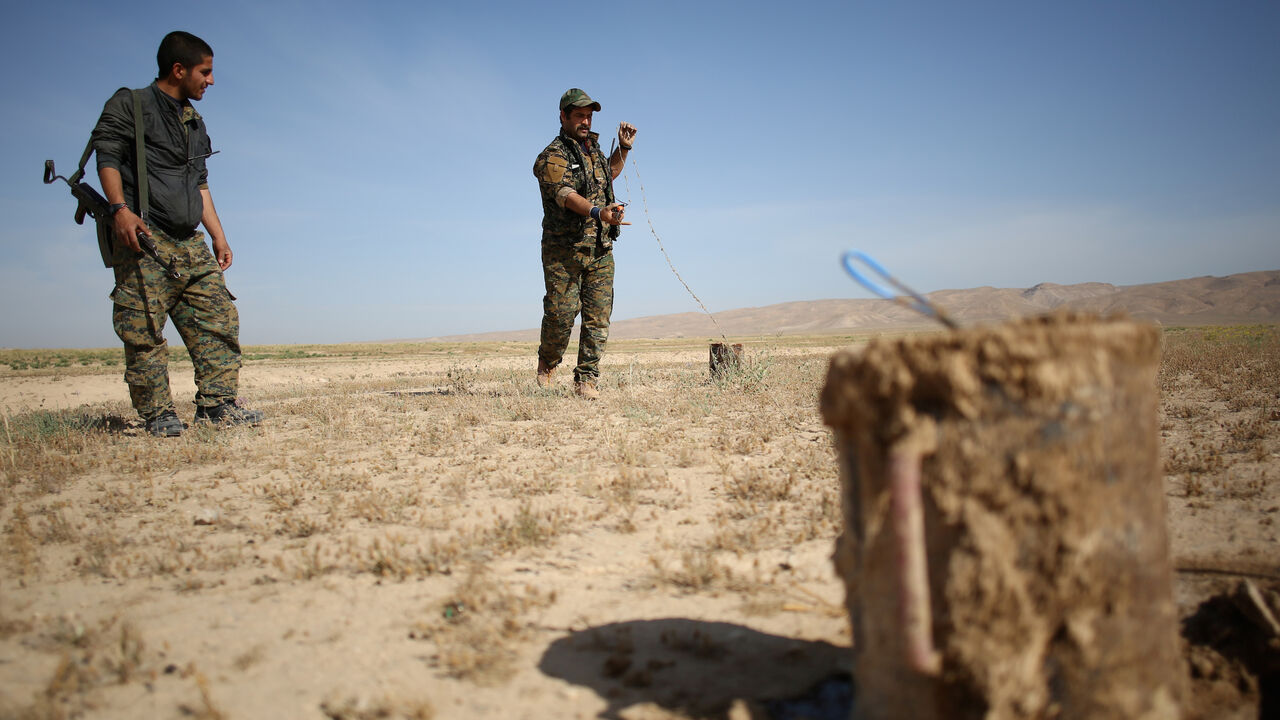 Members of the Sinjar Resistance Units (YBS), a militia affiliated with the Kurdistan Workers' Party (PKK), disarm an improvised explosive device placed by Islamic State fighters near the village of Umm al-Dhiban, northern Iraq, April 30, 2016. They share little more than an enemy and struggle to communicate on the battlefield, but together two relatively obscure groups have opened up a new front against Islamic State militants in a remote corner of Iraq. The unlikely alliance between the Sinjar Resistance 