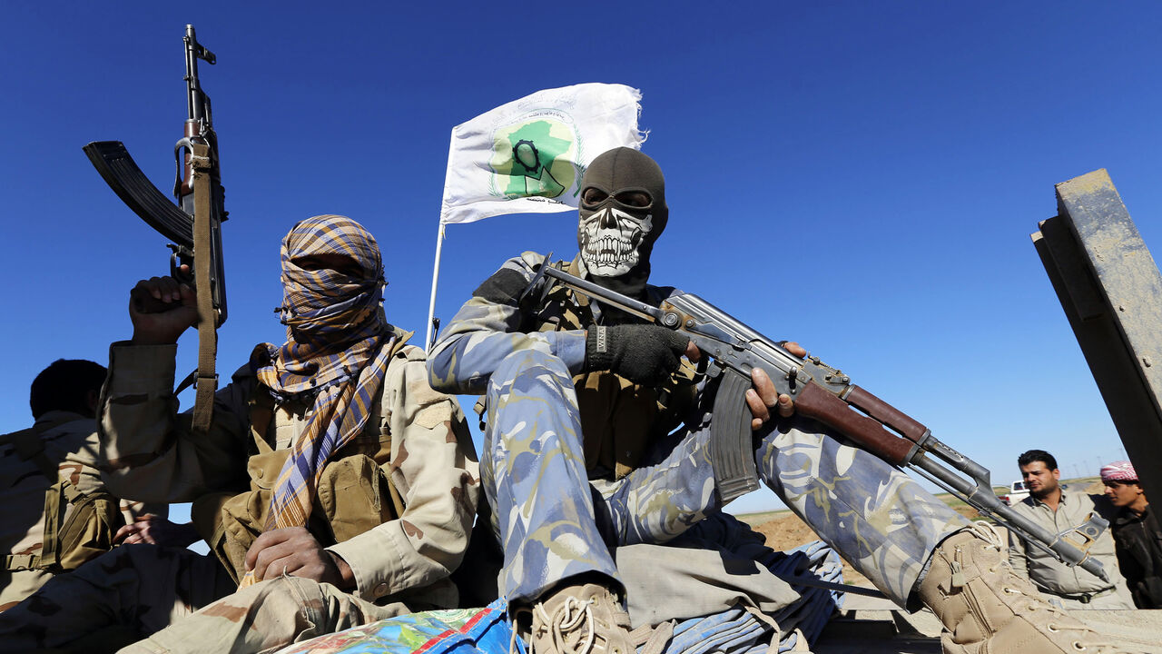 Masked Shi'ite fighters hold their weapons in Al Hadidiya, south of Tikrit, en route to the Islamic State-controlled al-Alam town, where they are preparing to launch an offensive on Saturday, March 6, 2015. Iraqi government forces and Iran-backed militiamen entered a town on the southern outskirts of Saddam Hussein's home city Tikrit on Friday, pressing on with the biggest offensive yet against Islamic State militants that seized the north last year. REUTERS/Thaier Al-Sudani (IRAQ - Tags: POLITICS CIVIL UNR