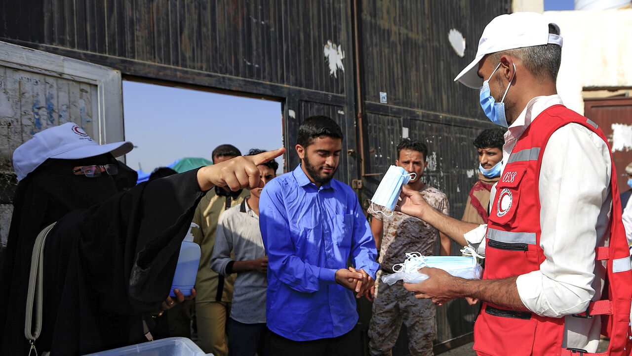 Face masks are distributed to Yemeni students upon their arrival to sit for their final secondary school exams in the capital Sanaa on August 15, 2020, amid the coronavirus pandemic crisis. (Photo by Mohammed HUWAIS / AFP) (Photo by MOHAMMED HUWAIS/AFP via Getty Images)