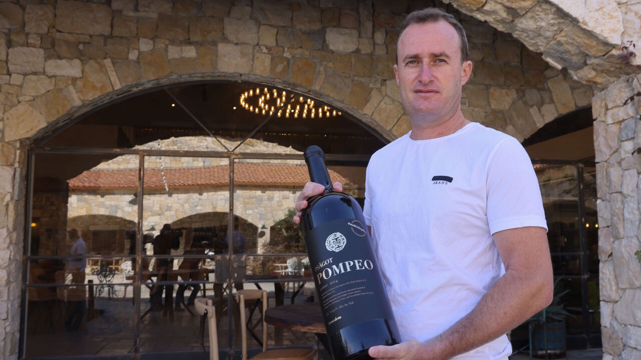Israeli winemaker Yaakov Berg's holds a bottle of his red blend named after US Secretary of State Mike Pompeo at the Psagot Winery in the settlers industrial park of Sha'ar Binyamin near the Israeli Psagot settlement in the occupied West Bank north of Jerusalem on November 18, 2020. - Berg's decision to name his red blend after US Secretary Mike Pompeo may capture attention, but for him the hashtag on the label's top right corner "#madeinlegality" is just as important, categorically rejecting the notion tha