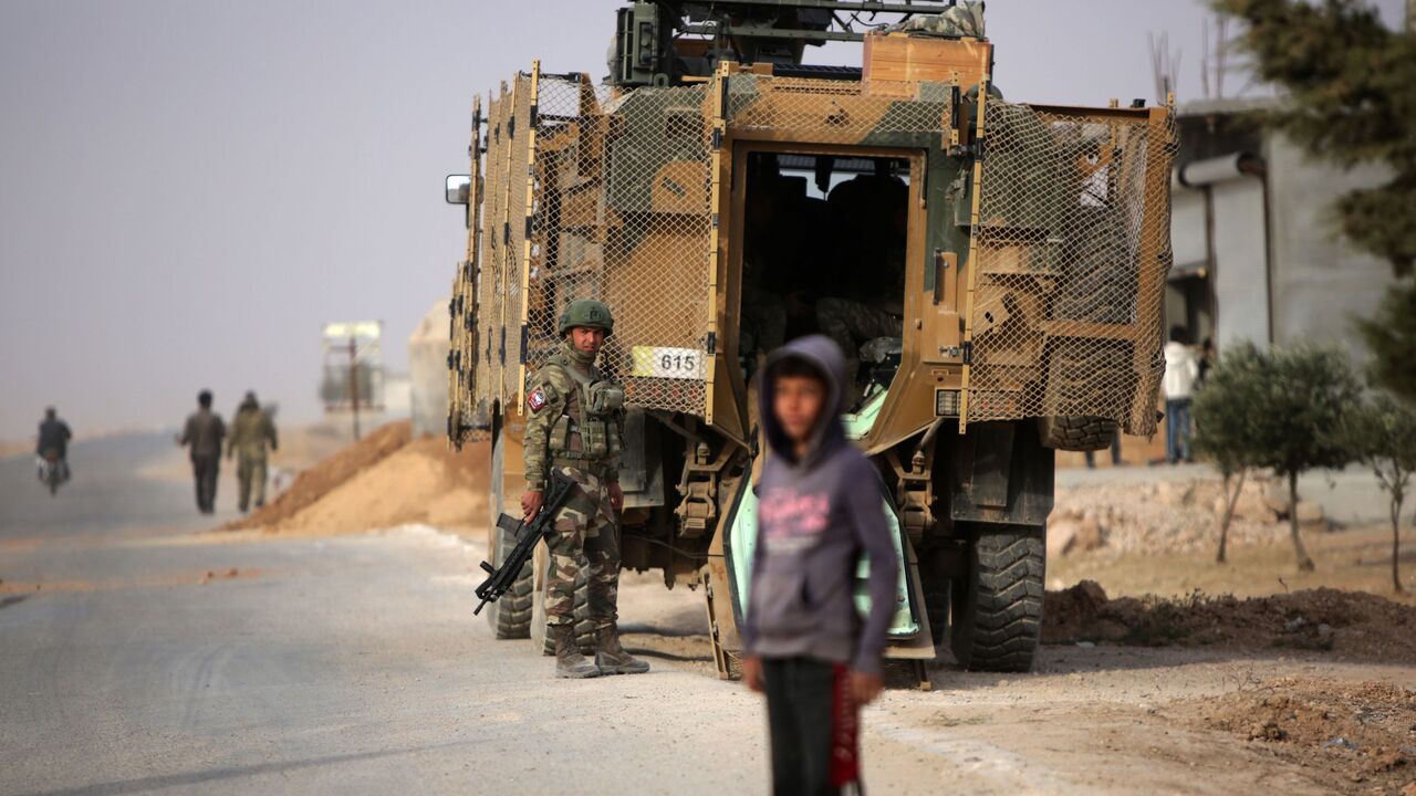 A Turkish soldier stands near his armoured vehicle on a highway near the northern Syrian town of Ain Issa in the countryside of the Raqqa region, on November 26, 2019, as Turkey-backed forces deploy reinforcements around the key town. - Ankara and its Syrian proxies launched on October 9 a cross-border attack against Kurdish fighters in northern Syria, which allowed Turkey, along with a subsequent Russian-Turkish accord, to control a strip of land on the Syrian side of the border. Ain Issa lies on the south