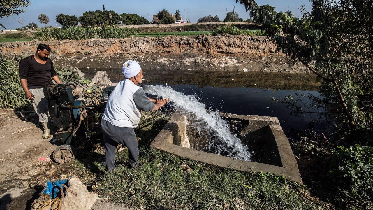 Egyptian farmer Mohamed Omar (C), 65, supplies his farmland with water from a canal, fed by the Nile river, in the village of Baharmis on the outskirts of Egypt's Giza province, northwest of the capital Cairo, on December 1, 2019. - Egypt has for years been suffering from a severe water crisis that is largely blamed on population growth. Mounting anxiety has gripped the already-strained farmers as the completion of Ethiopia's gigantic dam on the Blue Nile, a key tributary of the Nile, draws nearer. Egypt vi